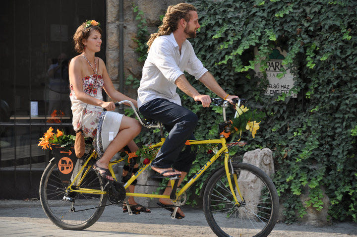 Llegando al casamiento en una bicicleta tándem amarilla.