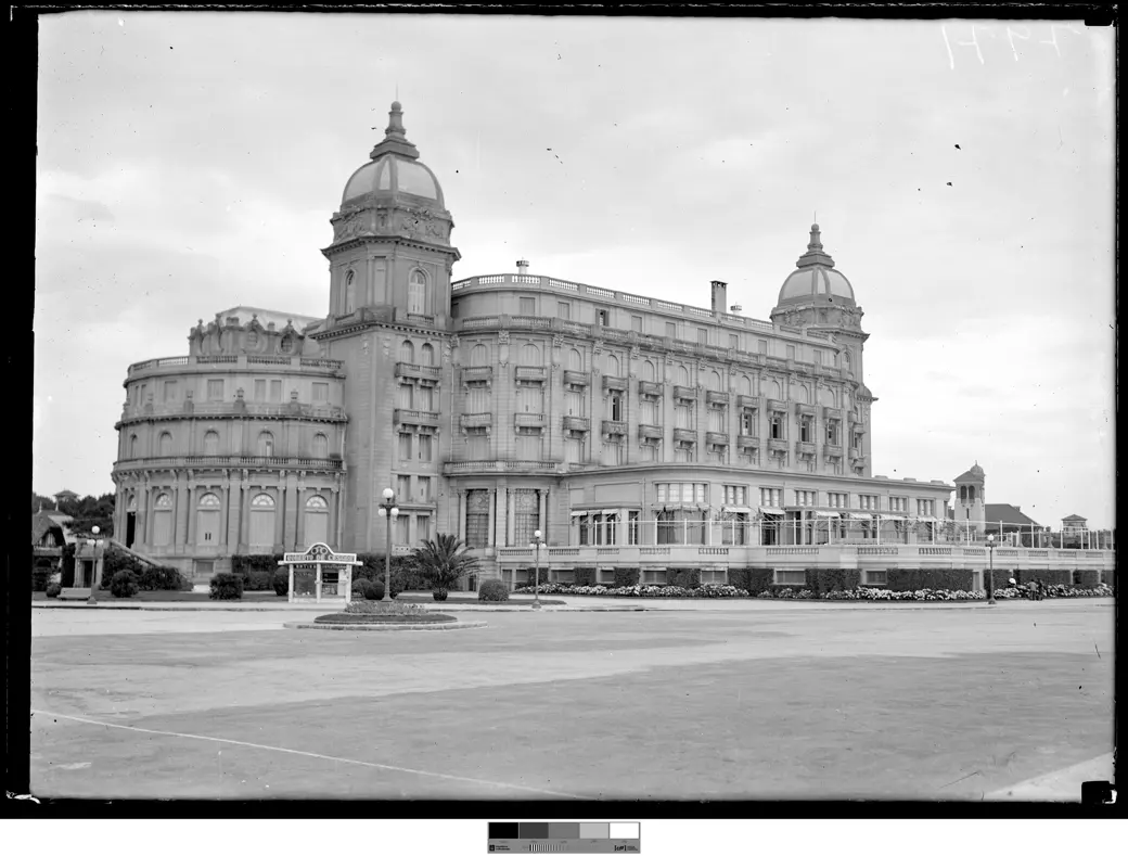 Foto histórica, 1943: el Hotel Carrasco con jardines maduros, setos formales y una explanada ajardinada de la rambla en primer plano.