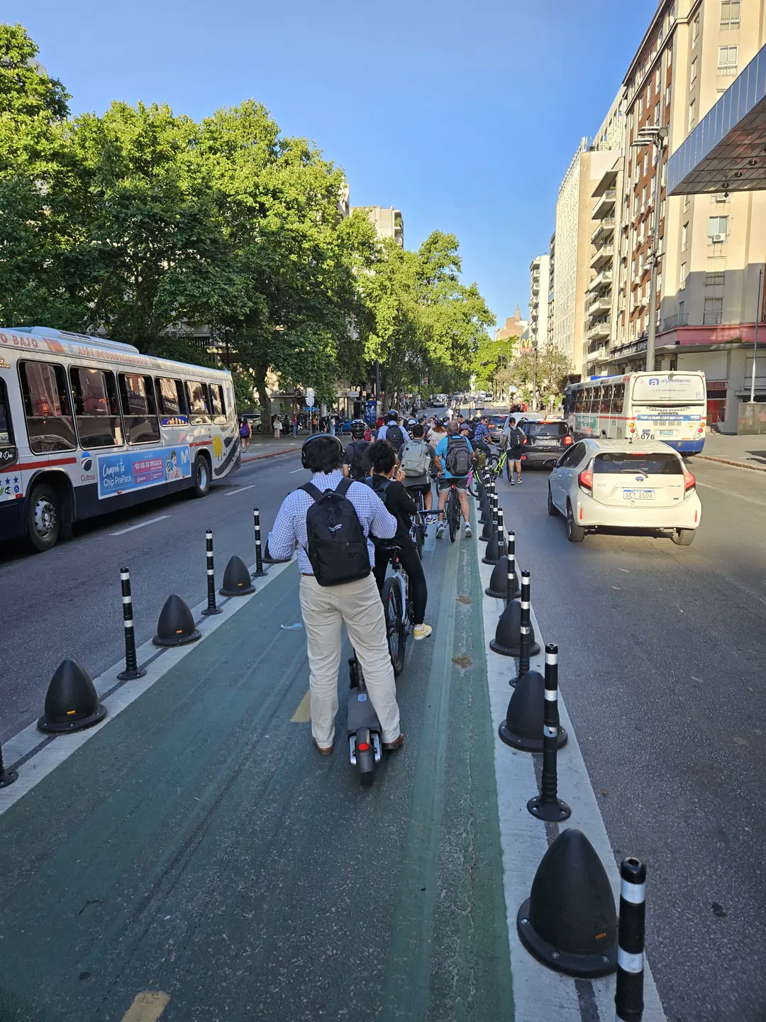 La ciclovía por el eje de 18 de Julio, con bicicletas y monopatines circulando por el centro de la calzada.